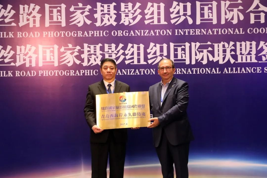 丝路国家摄影组织国际联盟名誉主席里卡尔多·布西向青岛西海岸西区授予“丝路国家摄影组织国际联盟青岛西海岸永久联络处”匾牌